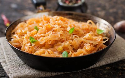 Stewed cabbage on the old wooden background in rustic style